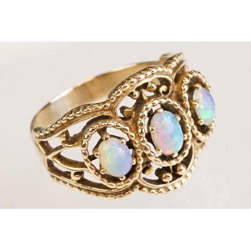 67 - Opal yellow metal three stone ring, three oval cabochon cut Ethiopian opals, displaying violet, blue... 