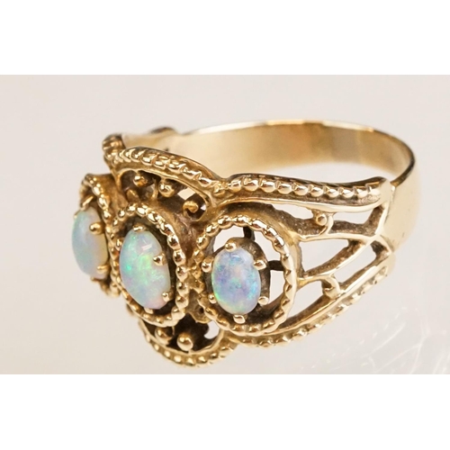 67 - Opal yellow metal three stone ring, three oval cabochon cut Ethiopian opals, displaying violet, blue... 