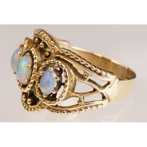 67 - Opal yellow metal three stone ring, three oval cabochon cut Ethiopian opals, displaying violet, blue... 