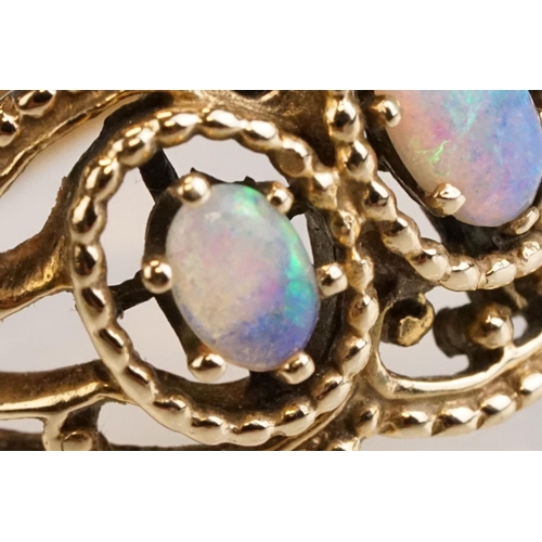 67 - Opal yellow metal three stone ring, three oval cabochon cut Ethiopian opals, displaying violet, blue... 