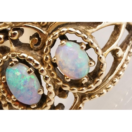 67 - Opal yellow metal three stone ring, three oval cabochon cut Ethiopian opals, displaying violet, blue... 