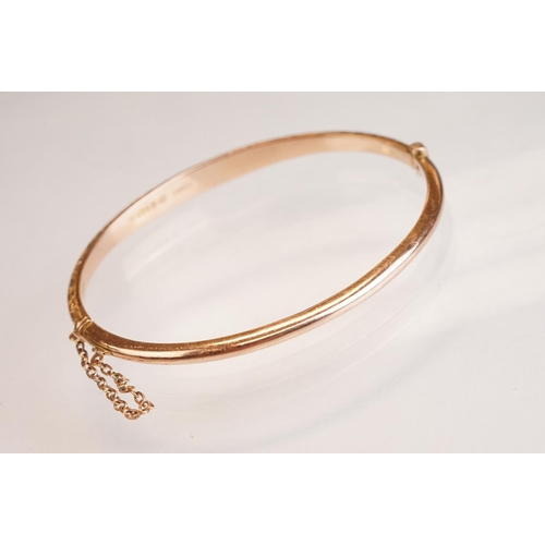 69 - Late 19th century 9ct rose gold hinged bangle, chased foliate scroll decoration to the upper half, t... 