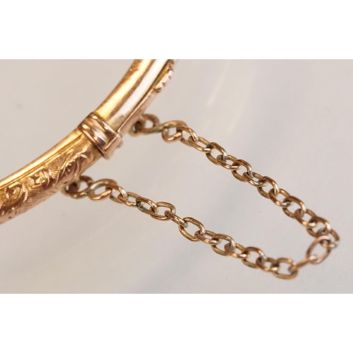 69 - Late 19th century 9ct rose gold hinged bangle, chased foliate scroll decoration to the upper half, t... 
