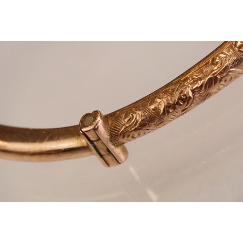 69 - Late 19th century 9ct rose gold hinged bangle, chased foliate scroll decoration to the upper half, t... 