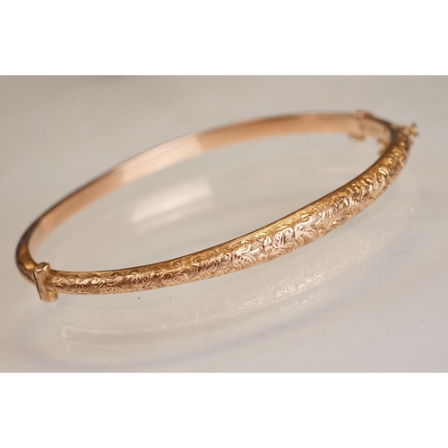 69 - Late 19th century 9ct rose gold hinged bangle, chased foliate scroll decoration to the upper half, t... 