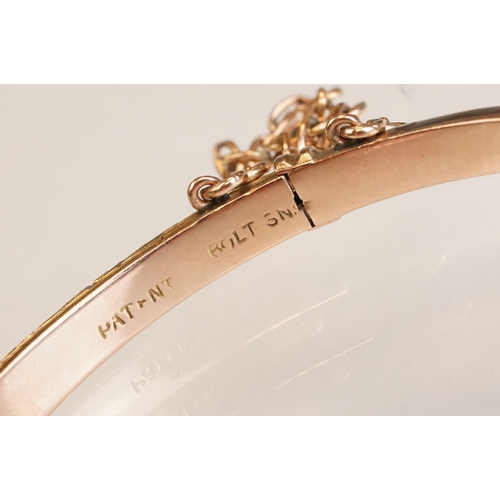 69 - Late 19th century 9ct rose gold hinged bangle, chased foliate scroll decoration to the upper half, t... 