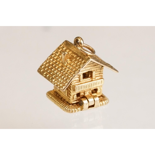 70 - Three 9ct yellow gold charms, an 8ct gold charm, a 14ct enamelled charm and a yellow metal charm (6)