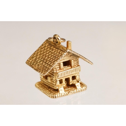 70 - Three 9ct yellow gold charms, an 8ct gold charm, a 14ct enamelled charm and a yellow metal charm (6)