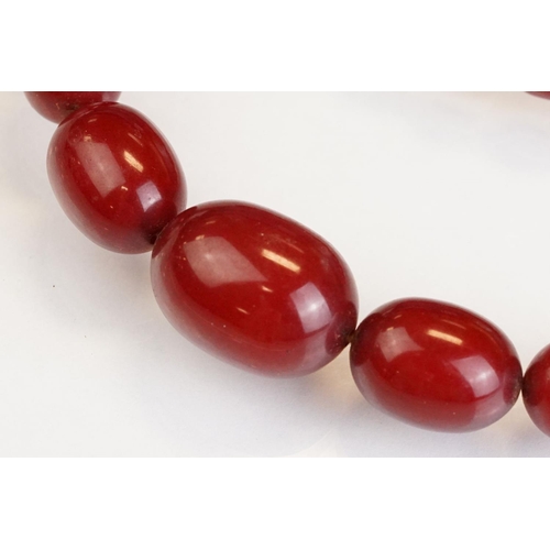73 - Cherry Bakelite amber graduated bead necklace, comprising fifty-six beads, the largest bead measurin... 