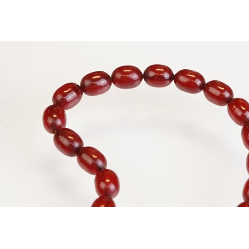 73 - Cherry Bakelite amber graduated bead necklace, comprising fifty-six beads, the largest bead measurin... 