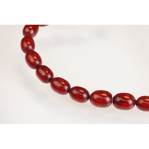 73 - Cherry Bakelite amber graduated bead necklace, comprising fifty-six beads, the largest bead measurin... 