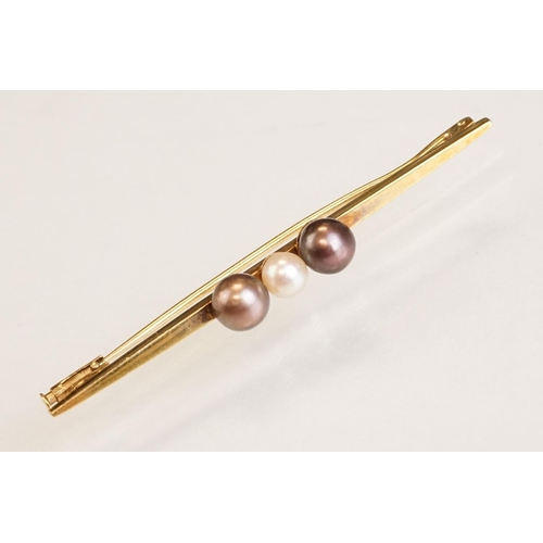 76 - Cultured pearl 14ct yellow gold bar brooch, white pearl to centre and two black pearls, trombone cla... 
