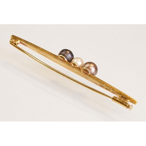 76 - Cultured pearl 14ct yellow gold bar brooch, white pearl to centre and two black pearls, trombone cla... 