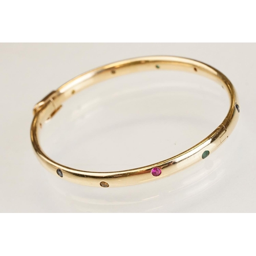 82 - Gem set 18ct yellow gold hinged bangle, pink, blue and yellow small round brilliant cut sapphires an... 