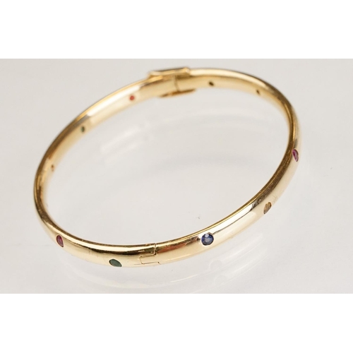 82 - Gem set 18ct yellow gold hinged bangle, pink, blue and yellow small round brilliant cut sapphires an... 