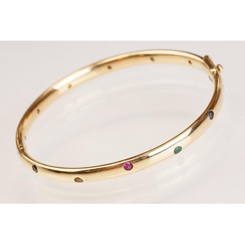 82 - Gem set 18ct yellow gold hinged bangle, pink, blue and yellow small round brilliant cut sapphires an... 