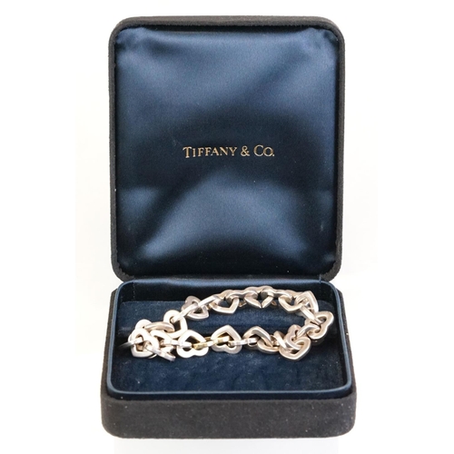 83 - Tiffany & Co parcel gilt silver heart shaped link bracelet, the centre heart gold plated, the clasp ... 