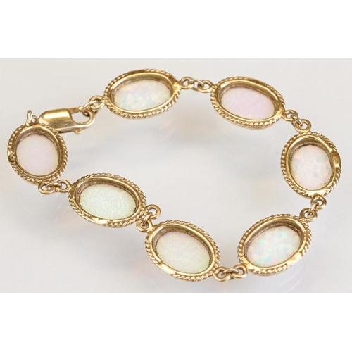 90 - Opal 9ct yellow gold bracelet, seven oval cabochon probably synthetic white opals, dimensions approx... 