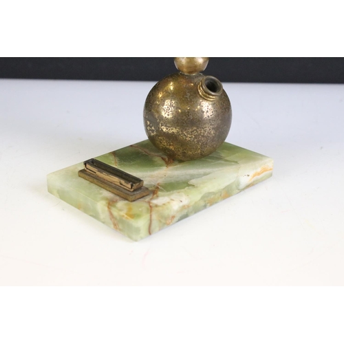 142 - Art Deco gilt metal table lighter in the form of a semi-nude lady dancer raised upon a globe, green ... 