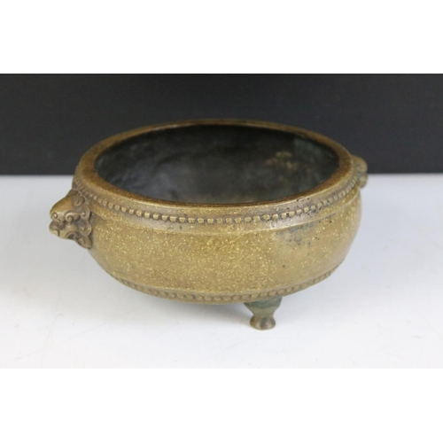 143 - Chinese twin-handled bronze censer, of circular form, handles modelled as lion masks, raised upon th... 