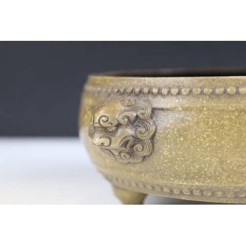 143 - Chinese twin-handled bronze censer, of circular form, handles modelled as lion masks, raised upon th... 