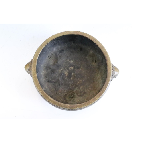 143 - Chinese twin-handled bronze censer, of circular form, handles modelled as lion masks, raised upon th... 
