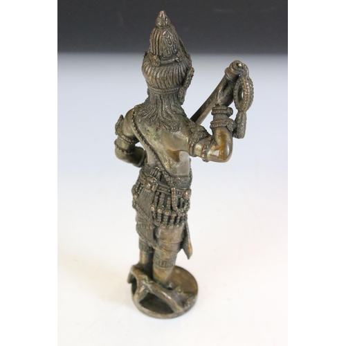 154 - Hindu bronze figure of a deity stood holding a weapon, approx 19cm high