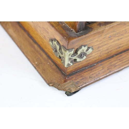 174 - Early 20th Century oak tantalus housing three cut glass decanters with faceted stoppers. Marked C702... 