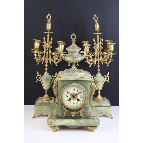 147 - Late 19th century onyx & gilt metal clock garniture, the clock with cream dial and surmounted by a t... 