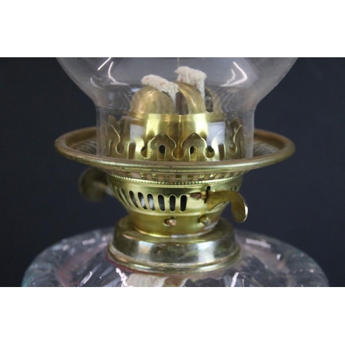175 - 19th Century Victorian brass and glass oil lamp having a clear glass reservoir raised on a brass col... 