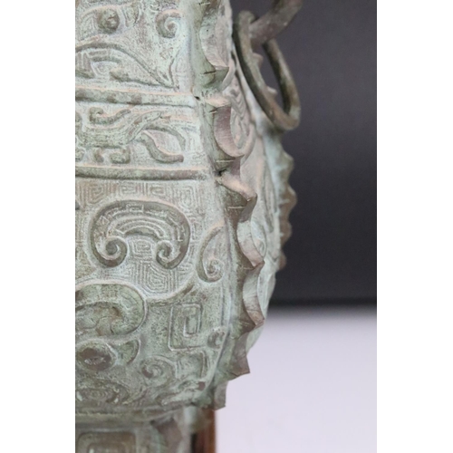 136 - Chinese archaic style bronze lamp, of square baluster form with flanking mask drop handles, raised o... 