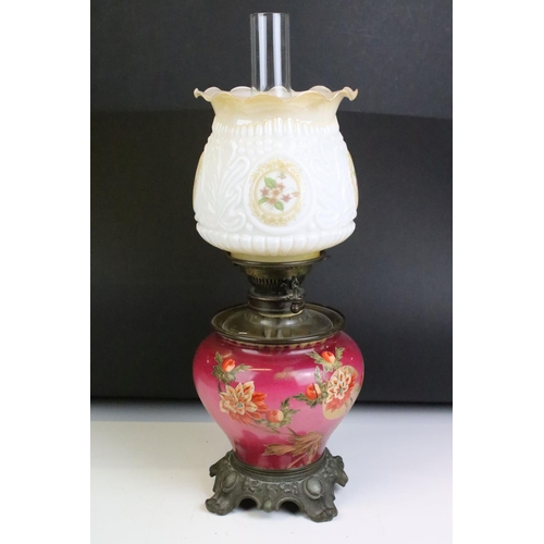 152 - An antique oil lamp having floral decoration to base and opaque shade and scrolled feet. Measures ap... 