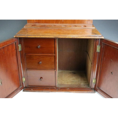 161 - Early 20th century mahogany smokers cabinet, the doors opening to three drawers, pipe rack to top. M... 