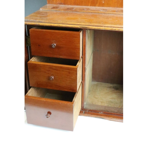 161 - Early 20th century mahogany smokers cabinet, the doors opening to three drawers, pipe rack to top. M... 