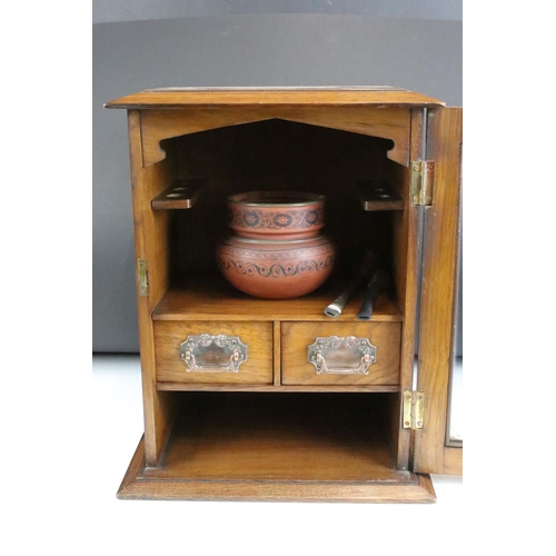 162 - Edwardian oak smokers cabinet, the glazed door opening to two drawers, and upper and lower storage c... 