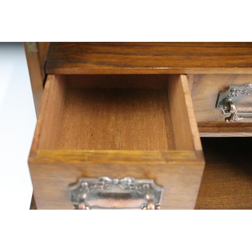 162 - Edwardian oak smokers cabinet, the glazed door opening to two drawers, and upper and lower storage c... 