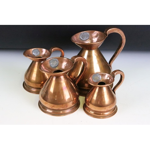 172 - A set of four copper graduated copper jugs from 1/2 Gill through to 1 Pint, proof marks to jugs rims... 