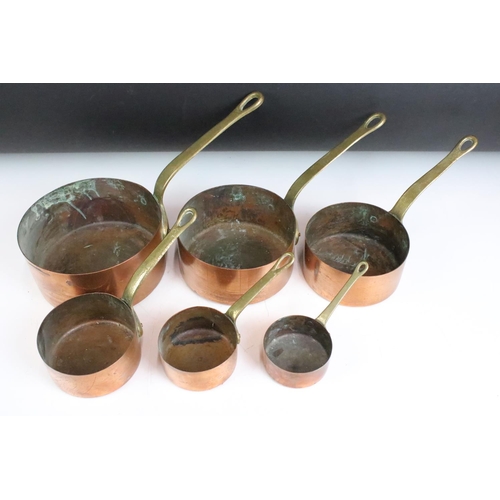 176 - A set of six graduated copper saucepans with brass handles, largest measures 16cm diameter.