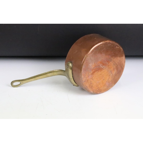 176 - A set of six graduated copper saucepans with brass handles, largest measures 16cm diameter.