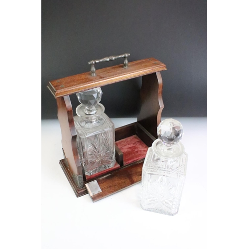 186 - Early 20th century Two Bottle Oak Tantalus with a pair of cut glass decanters.