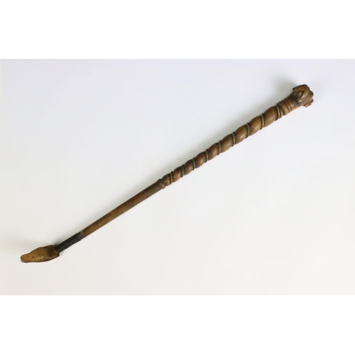 194 - A finely carved wooden riding crop with dog's head finial, measures approx 37cm in length.