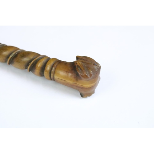 194 - A finely carved wooden riding crop with dog's head finial, measures approx 37cm in length.