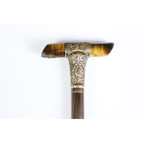 195 - An antique parasol or walking stick handle, tigers eye cross handle with hallmarked 15ct gold mounti... 