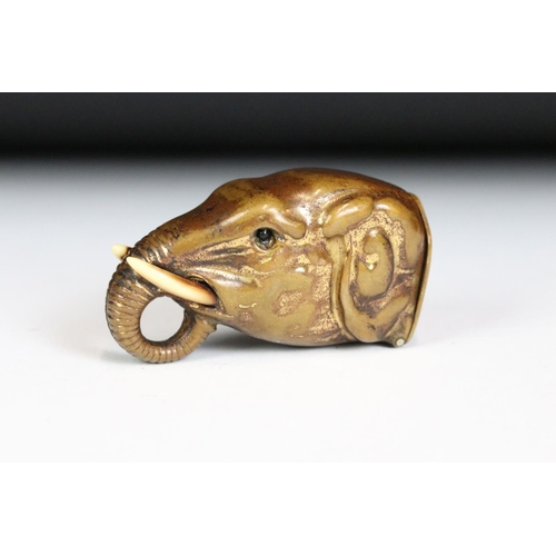 222 - A brass vesta case in the form of an elephant with inlaid eyes, measures approx 5cm in length.