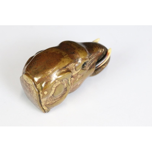 222 - A brass vesta case in the form of an elephant with inlaid eyes, measures approx 5cm in length.