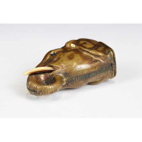 222 - A brass vesta case in the form of an elephant with inlaid eyes, measures approx 5cm in length.