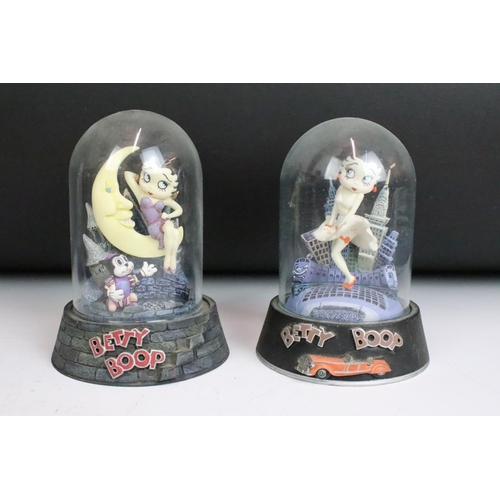 261 - A collection of eight Betty Boop hand painted resin sculptures within glass domes.