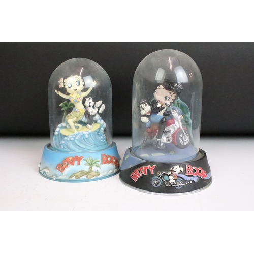 261 - A collection of eight Betty Boop hand painted resin sculptures within glass domes.