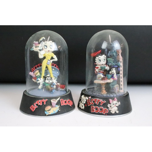 261 - A collection of eight Betty Boop hand painted resin sculptures within glass domes.