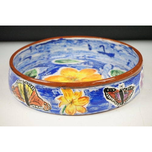 35 - Hazel Leach studio pottery circular bowl, with hand painted floral and butterfly decoration on a blu... 